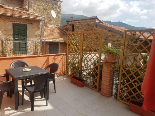 a patio with a table and chairs on a balcony at Piccolo rifugio nel Verde in Chiusavecchia