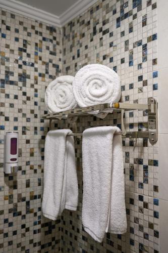 a bathroom with white towels on a rack at Aracan Hotac Ras El Bar in Ras El Bar