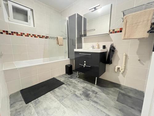 a bathroom with a sink and a bath tub at Maison moderne avec terrasse & parking in Clermont-Ferrand
