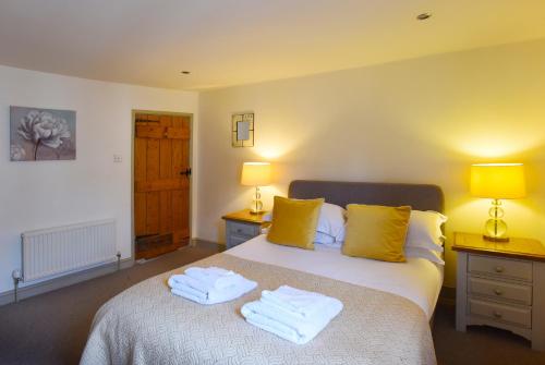 ein Schlafzimmer mit einem Bett mit zwei Handtüchern darauf in der Unterkunft Historic Fireman's Cottage - Cosy Home - Close To Town Centre in Canterbury