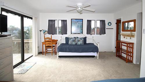 une chambre avec un lit et un ventilateur de plafond dans l'établissement Renascence Cottage, à Cape May Point