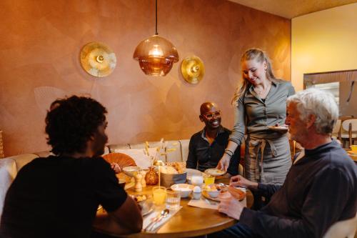 a group of people sitting around a table eating at Strandhotel Camperduin in Schoorl