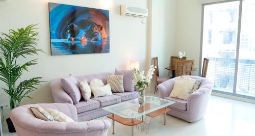 マドリードにあるOshun Sanchinarro Seasonal Living Loftsのソファと椅子2脚とテーブルのあるリビングルーム