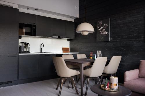 une cuisine avec une table et des chaises dans une pièce dans l'établissement Le Chalet Lingonberry D3 Ski-in Ski-out by Aavalevi, à Levi