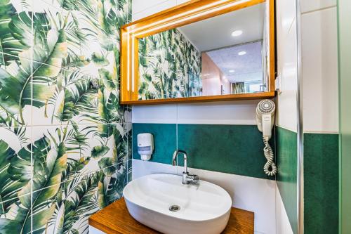 um banheiro com uma pia e um espelho em Art Hotel Simona em Sófia