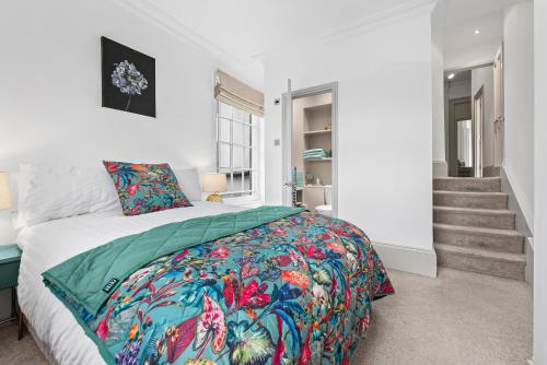 a bedroom with a bed with a colorful comforter at Spacious Apartment with Balcony, Clarendon Square in Leamington Spa