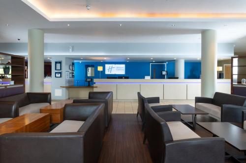 a restaurant with couches and tables and a bar at Holiday Inn Express London Greenwich by IHG in London