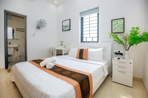 une chambre avec un grand lit avec des draps blancs dans l'établissement Ruby Hotel Biển Vũng Tàu, à Vung Tau