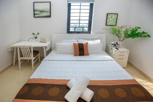 une chambre avec un grand lit et une table dans l'établissement Ruby Hotel Biển Vũng Tàu, à Vung Tau