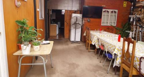 a room with long tables and chairs and a refrigerator at Hospedaje con Pensión Completa in Angol