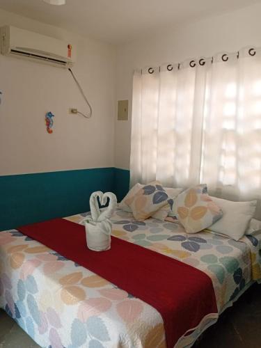 a bedroom with a bed with a heart shaped towel at Pousada La Floratta in Paulista