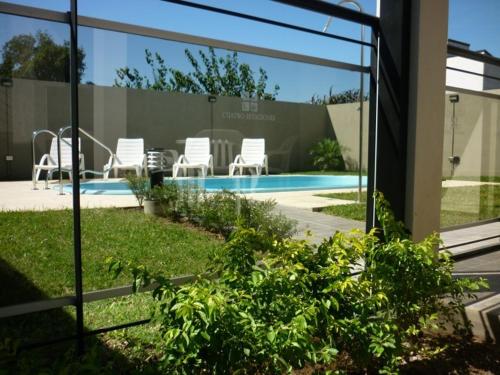 vistas a una piscina con sillas blancas en Cuatro Estaciones, en San José