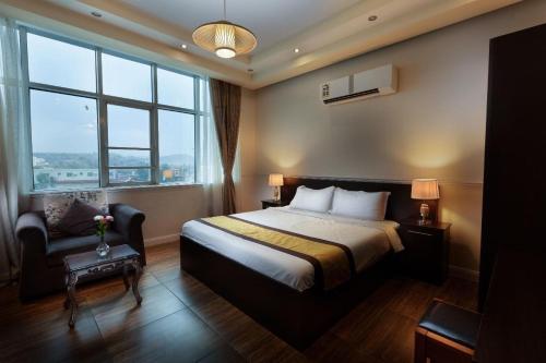 a bedroom with a bed and a chair and windows at Hotel Gardenz View 1 in Taif