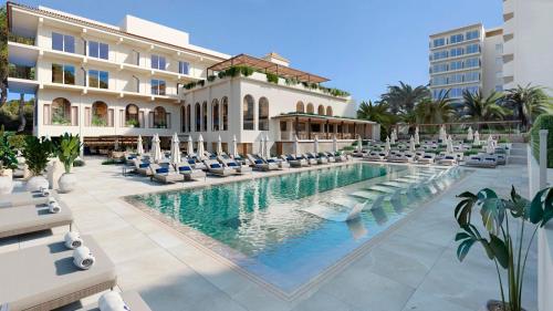 a resort with a swimming pool and lounge chairs at Smy Portocolom in Portocolom