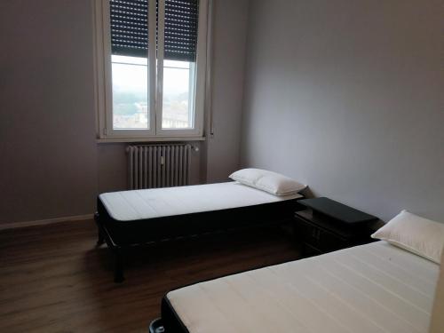two beds in a small room with a window at saffi15 in Sannazzaro deʼ Burgondi
