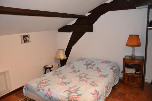 a bedroom with a bed with a floral bedspread at Chambres D'hotes Beaupel in Neuvy-en-Mauges