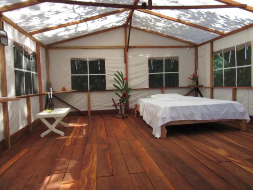 a bedroom in a tent with a bed in it at Sabalo Lodge Tours and Cabins in Sierpe