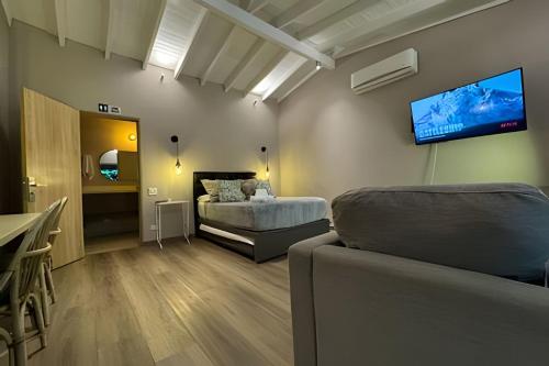 a bedroom with a bed and a tv on the wall at Apto BR Suites 6 min de Provenza, encanto natural in Medellín