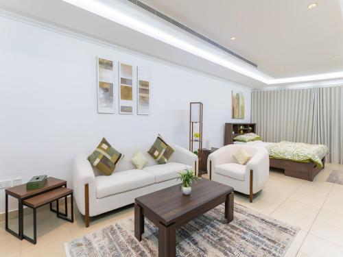 a living room with a couch and a bed at Furnished Studio In The Pearl - FGR2 in Doha