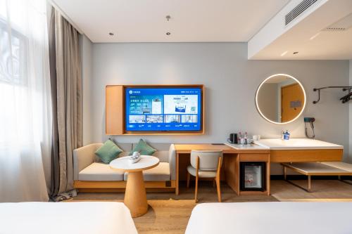 a hotel room with a tv on the wall at Hanting Hotel Beijing Garden Expo Park in Beijing