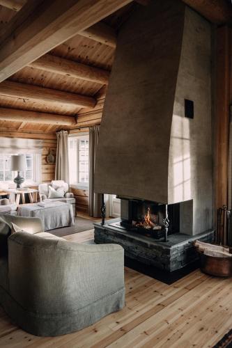 a living room with a fireplace and a couch at Storfjord Hotel in Skodje