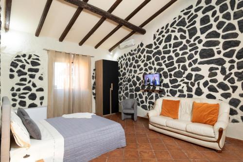 een slaapkamer met een bed en een bank bij Villa Jelù in Castiglione di Sicilia