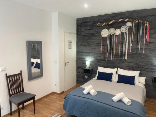 a bedroom with a large bed and a chair at Casa 4P - House4People - Alojamento Local in Penacova
