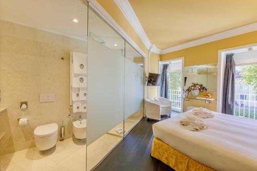 a bathroom with a large bed and a glass shower at Greif Hotel & Spa in Trieste