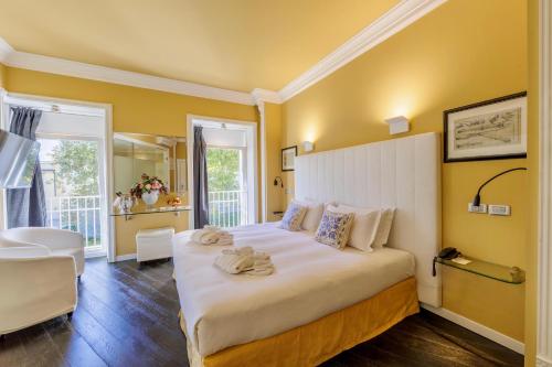 a bedroom with a large white bed with yellow walls at Greif Hotel & Spa in Trieste