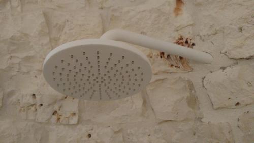 a white strainer on top of a stone wall at Dimora Sumerano in Alberobello