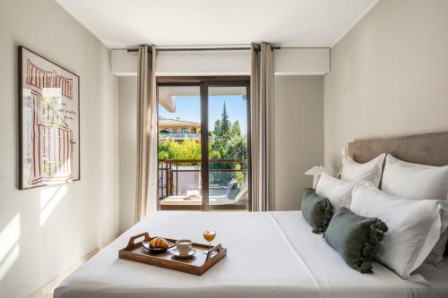 Vivre Cannes l Parking l Balcony l 15min to La Croisette في كان: غرفة نوم بها سرير عليه صينية طعام