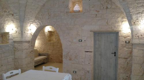 een kamer met een witte tafel en een deur bij Dimora Sumerano in Alberobello