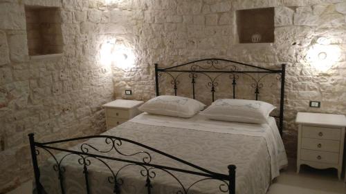 a bedroom with a black bed with two white pillows at Dimora Sumerano in Alberobello