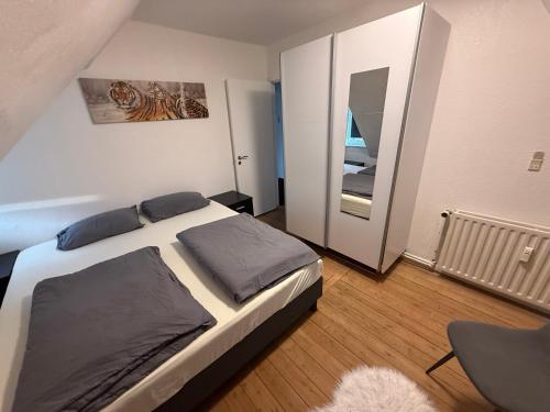 a small bedroom with a bed and a mirror at Hel ændre men hyggelig lejlighed in Sønderborg