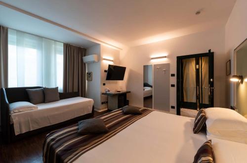 a hotel room with two beds and a couch at Hotel Seaview in Rimini