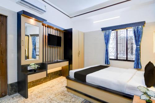 a bedroom with a large bed and a television at Super Hotel O Howrah Railway Station in Salkhia