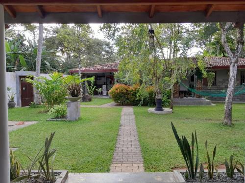 a garden with a brick path in front of a building at Villa Ali in Galle
