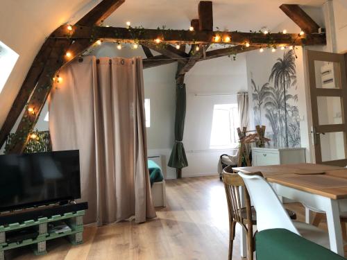 a living room with a table and a television at Le Godefroy de Bouillon in Boulogne-sur-Mer
