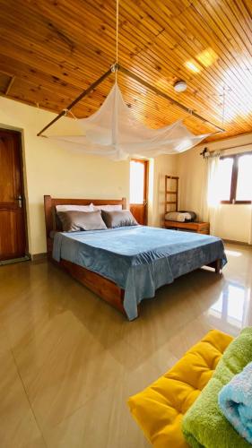 a bedroom with a large bed with a wooden ceiling at Minerva Apart in Ranomafana