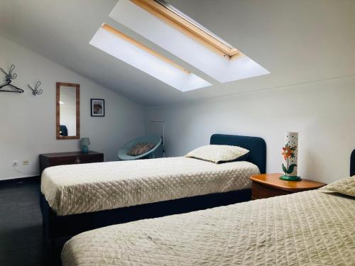 ein Schlafzimmer mit zwei Betten und einem Dachfenster in der Unterkunft AdaBibas in Vermelho
