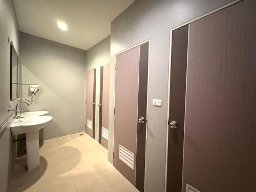 een badkamer met een wastafel, een toilet en een spiegel bij At Hua Lamphong Hotel in Bangkok