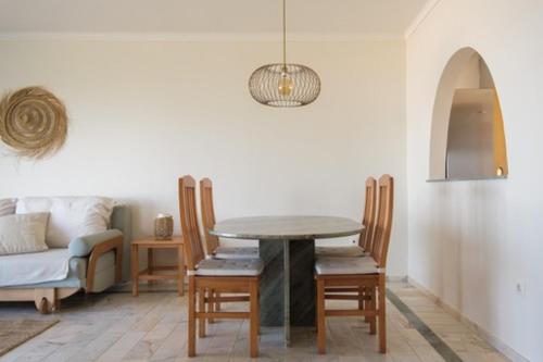 een eetkamer met een tafel en een bank bij Panorama SeaView House in Marinha Grande