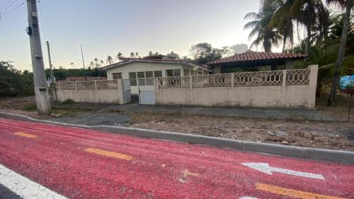 a house with a fence and a red road at Casa Aver o Mar in Sirinhaém