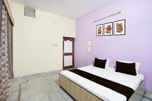 a bedroom with a large bed with purple walls at SPOT ON Muskan Lodge & Restaurants in Jāmul