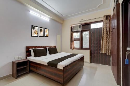 a bedroom with a large bed and a window at Hotel O Jagatpura Central Railway Station Jaipur in Jaipur