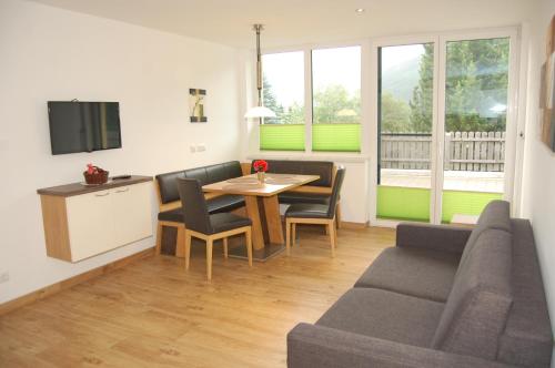 a living room with a table and a couch at Sonnenchalet Bäckenbauer in Sankt Michael im Lungau