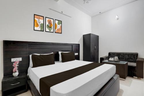 a bedroom with a large bed and a desk at Hotel O Shree Guru Kanha Vaishno Dham in Chhatikara