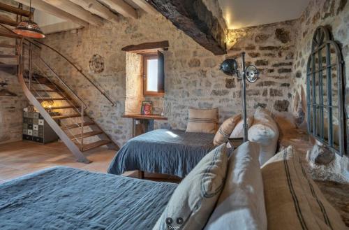 a bedroom with two beds and a staircase at Mas del Lum in Boussac