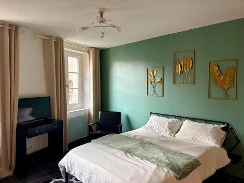 a bedroom with a green wall with a bed and a chair at Le Perché in Melun