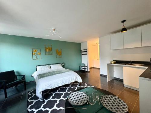a bedroom with a bed and a table and a kitchen at Le Perché in Melun